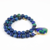 Eine Edelsteinkette aus runden Lapislazuli-Steinen mit einem großen tropfenförmigen Anhänger mit einem ähnlichen blau-grünen Muster, eingefasst in 750er Gelbgold. Die Kette ist elegant kreisförmig gewickelt.