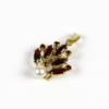 Ein Anhänger mit der Bezeichnung „750/Anhänger Gelbgold mit Perle und Granat“ weist ein blattähnliches Design mit mehreren roten Edelsteinen im Marquiseschliff und einer einzelnen runden Perle auf, alles vor einem weißen Hintergrund.