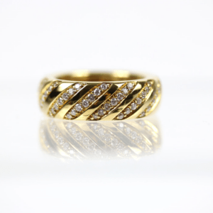 Der 750/Gelbgold Ring mit Brillantreihen besteht aus diagonalen Reihen kleiner Diamanten, die in Gold gefasst sind. Die reflektierende Oberfläche darunter verstärkt die glänzende Textur des Rings, alles vor einem schlichten weißen Hintergrund.