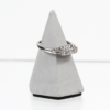 Ein 750er Weißgoldring mit drei Brillanten von insgesamt etwa 0,3 Karat (Vs/H) wird auf einem grauen, pyramidenförmigen Ständer mit schwarzem Sockel präsentiert, der auf einer reflektierenden Oberfläche steht.