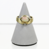 Der 585/Gelbgold Ring mit Opal und Brillant ca. 0,025ct. wird auf einem grauen, kegelförmigen Ständer vor weißem Hintergrund präsentiert und zeigt ein Goldband mit einem ovalen Opalstein an der Oberseite und einem runden Diamanten an der Unterseite.