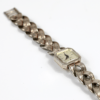 Die 835/DAU Silber-Damenarmbanduhr Handaufzug BWC Schwabylon präsentiert sich auf einem weißen Hintergrund und verfügt über ein quadratisches Zifferblatt mit schwarzen Zeigern und ohne Ziffern, ergänzt durch ein geflochtenes Metallband mit Faltschließe.